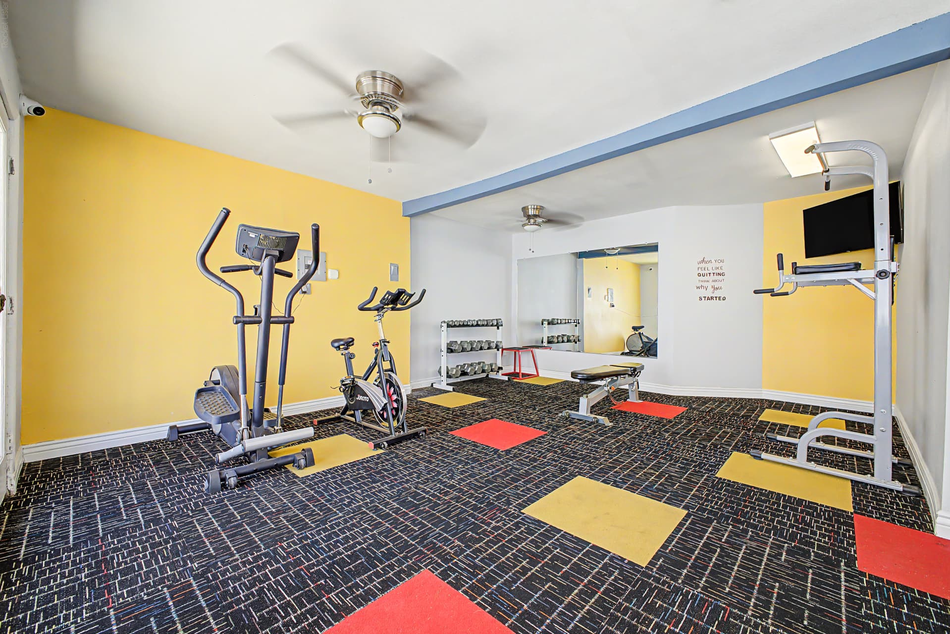 Fitness room with elliptical, stationary bike, and free weights